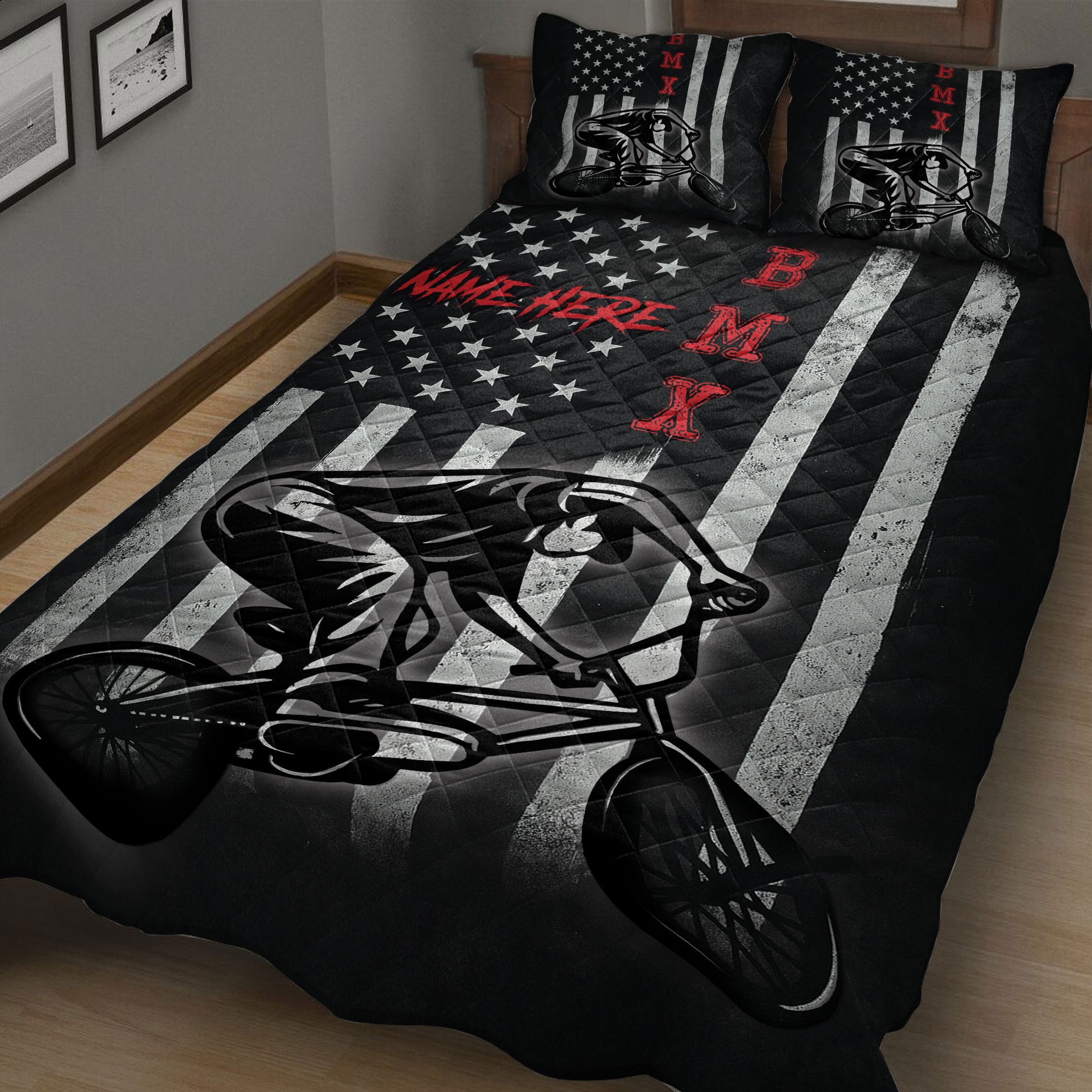 Black BMX quilt blanket spread across a bed with large freestyle cyclist artwork and graphic stripes