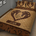 Close bedroom view of a brown horse quilt blanket featuring paired horses, horseshoes, and rustic western artwork