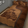 Close-up of brown quilt blanket featuring detailed dump truck illustrations and construction vehicle accents