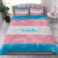 Transgender pride quilt bedding styled in a bright bedroom with pink, white, and blue stripes