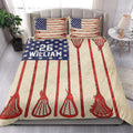 Lacrosse quilt blanket styled on a bed with repeated red sticks and blue patriotic accent artwork