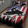 Snowmobile quilt spread across a bedroom with bold black rider silhouettes, red stripes, stars, and trees