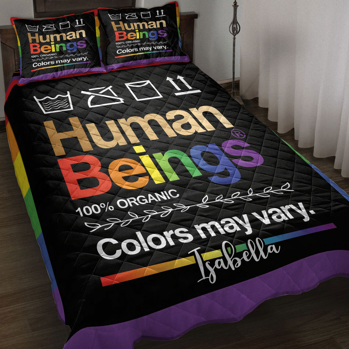 Black LGBT quilt blanket displayed on a bed with bold rainbow colors and inclusive artwork