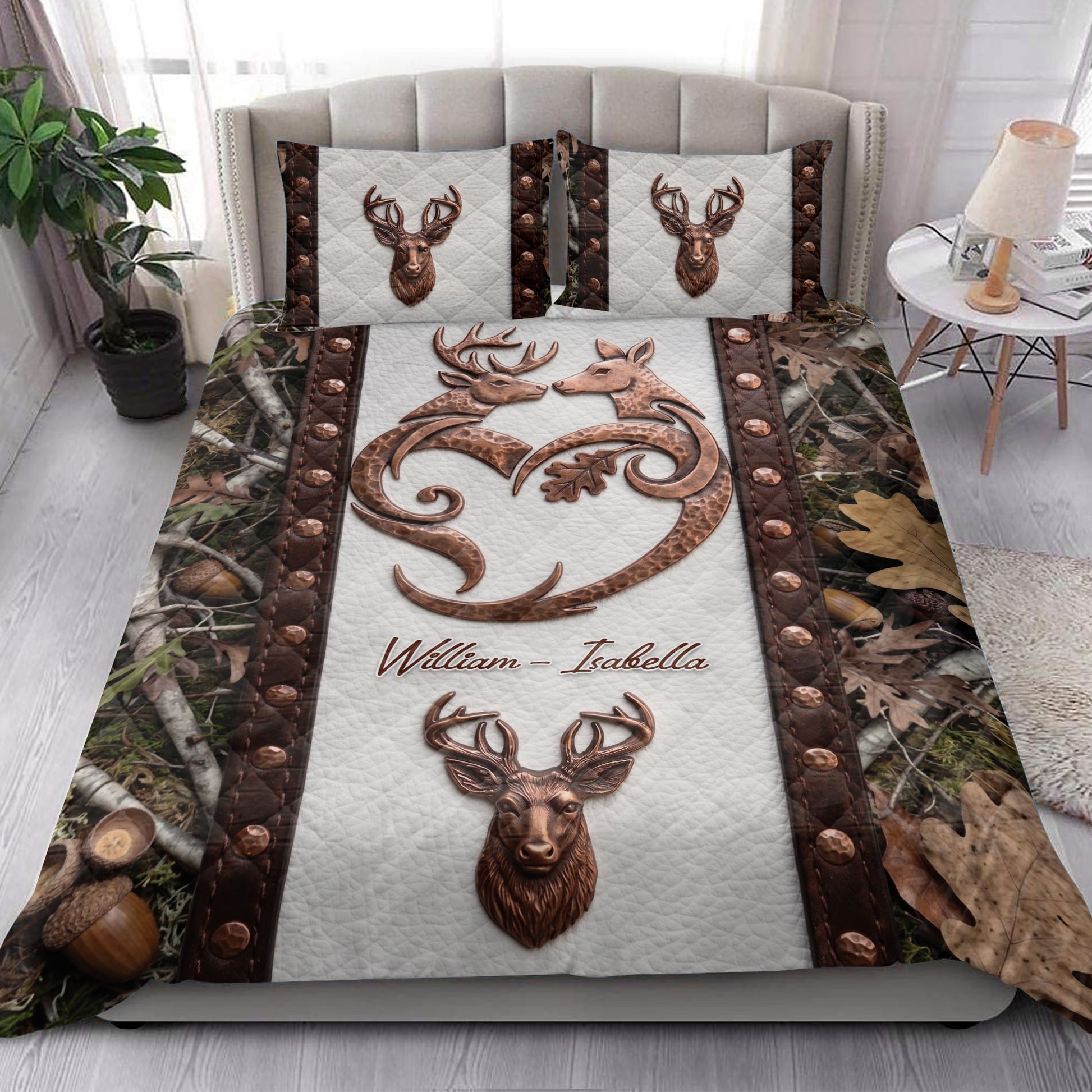 Hunting quilt blanket styled on a bedroom bed with deer, antler, woodland, and autumn leaf artwork