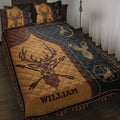 Hunting quilt blanket displayed on a bed with deer and antler artwork in brown, black, and gold