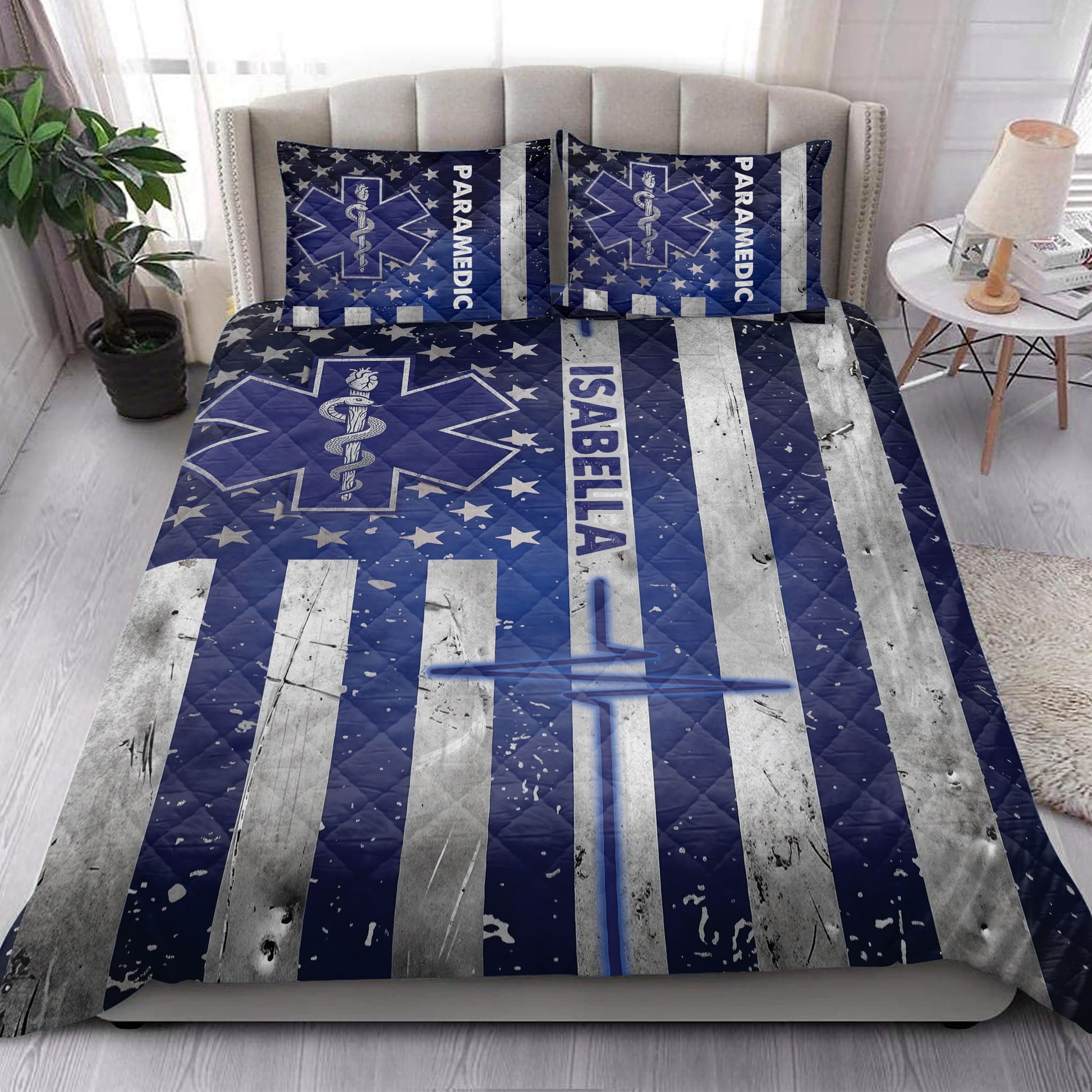 Paramedic quilt bedding set styled on a modern bed with navy medical star artwork and silver striped accents