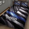 Black and blue police quilt blanket arranged on a bed with patriotic flag-inspired artwork