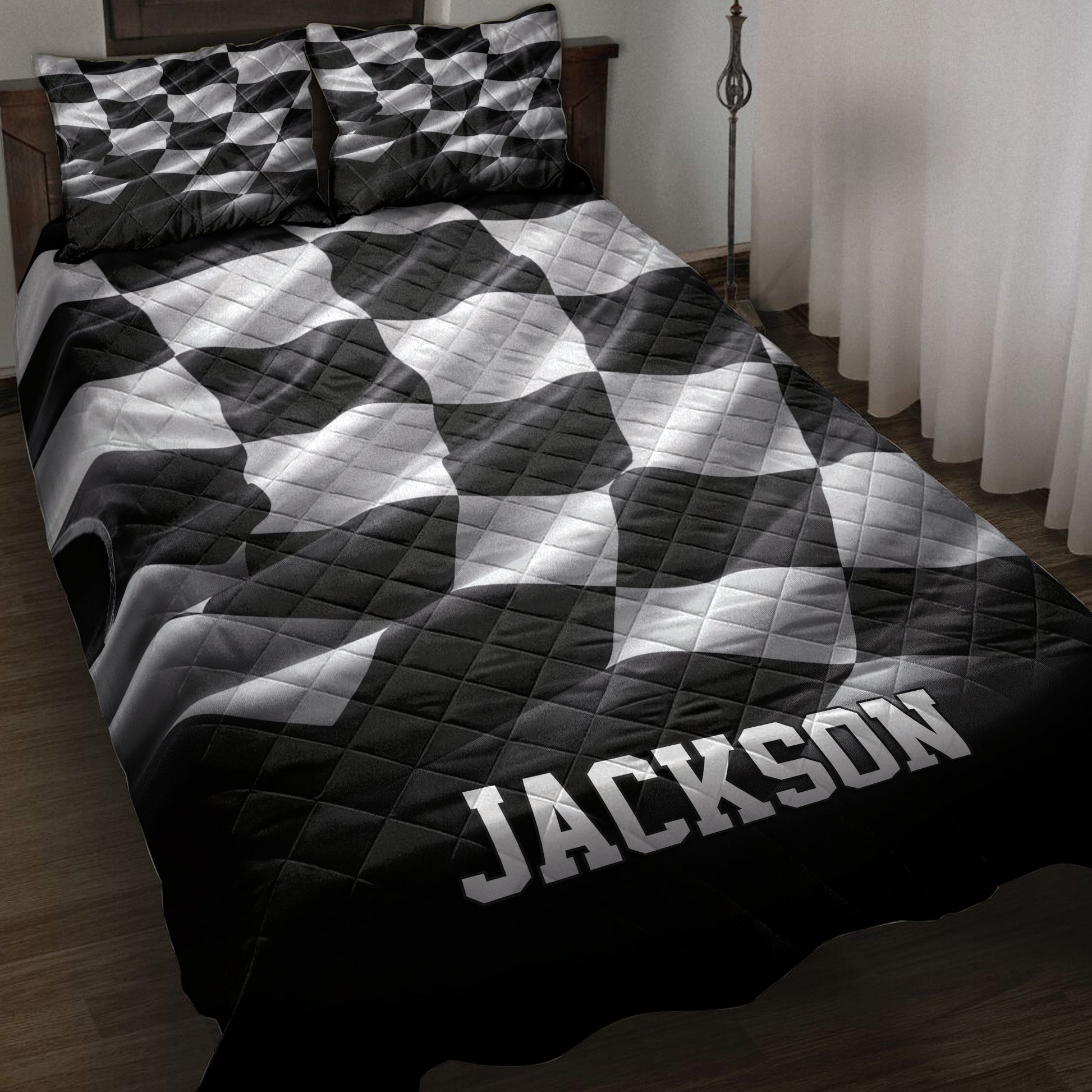 Black and white checkered racing quilt blanket styled on a bed in a dark wood bedroom