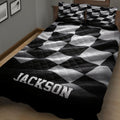 Checkered flag racing quilt displayed on a bed with bold monochrome bedroom decor