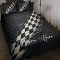 Black racing quilt blanket bedding set with checkered flag artwork on a bedroom bed