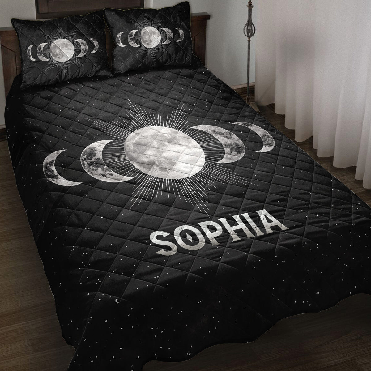 Black Wicca quilt blanket with moon phase artwork and radiant full moon displayed on a bedroom bed