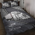 Trucker quilt blanket displayed on a bed with semi-truck artwork in dark gray and silver tones