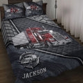 Trucking quilt blanket displayed on a bed with red semi-truck artwork and dark tire-pattern accents