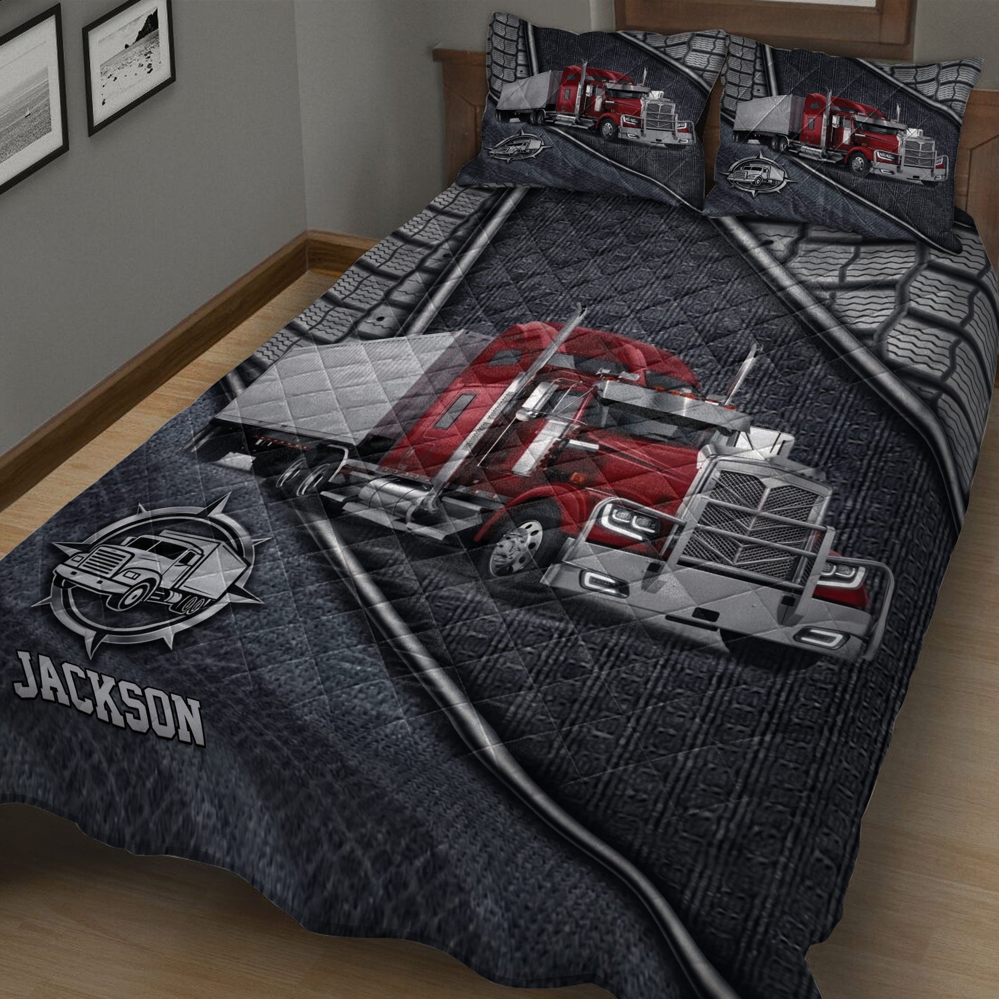 Truck-themed quilt spread across a bed with large red semi-truck artwork and monochrome truck emblems