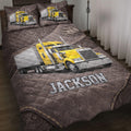 Trucker quilt bedding set on a bed with yellow semi-truck artwork, road markings, and dark paisley details