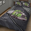Close-up bedroom view of a dark trucker quilt blanket featuring green semi-truck and trailer artwork