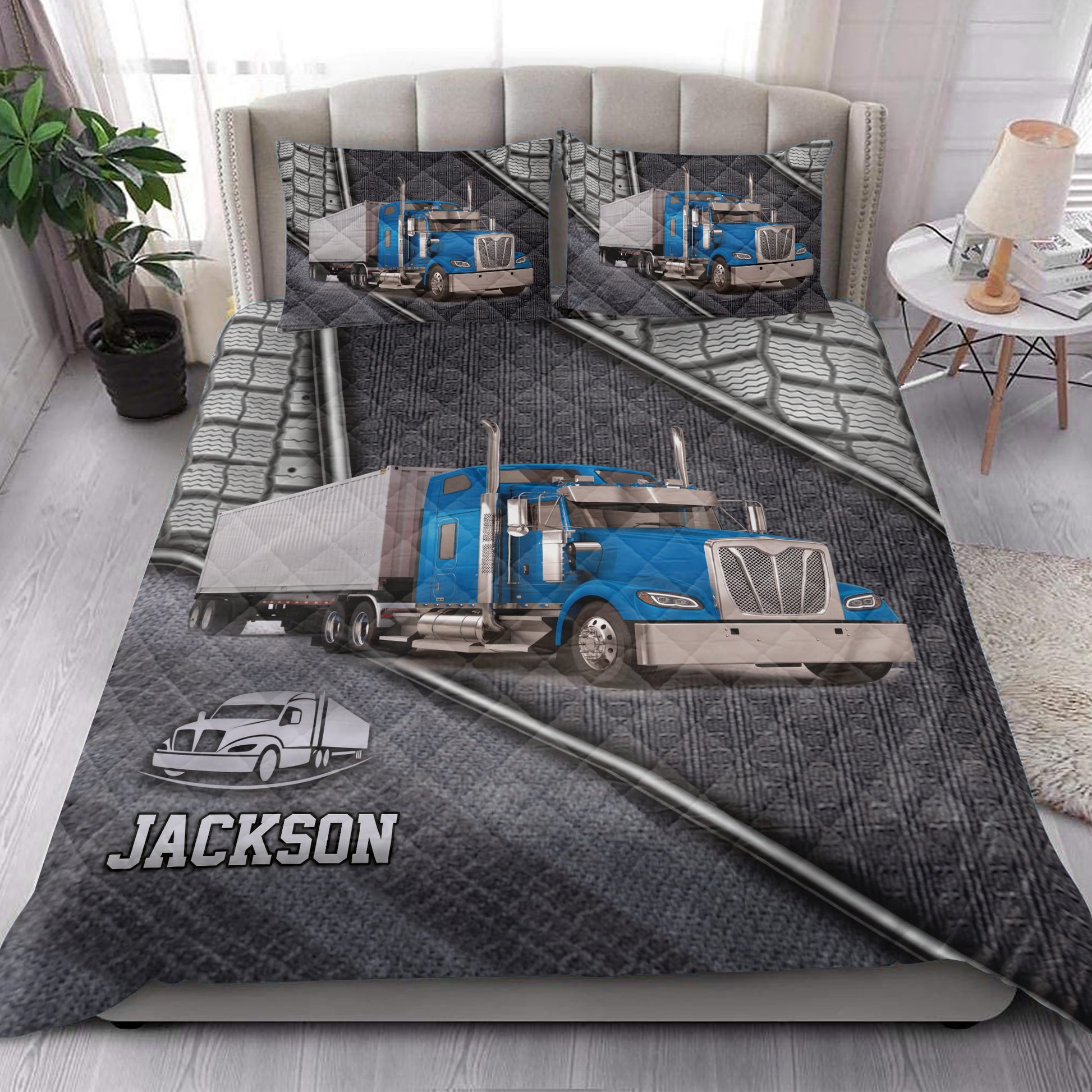Trucker quilt blanket styled in a bedroom with blue semi truck artwork and dark gray automotive details