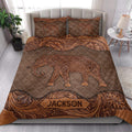 Bedroom display of a brown elephant quilt blanket with ornate floral borders and elephant pillowcases