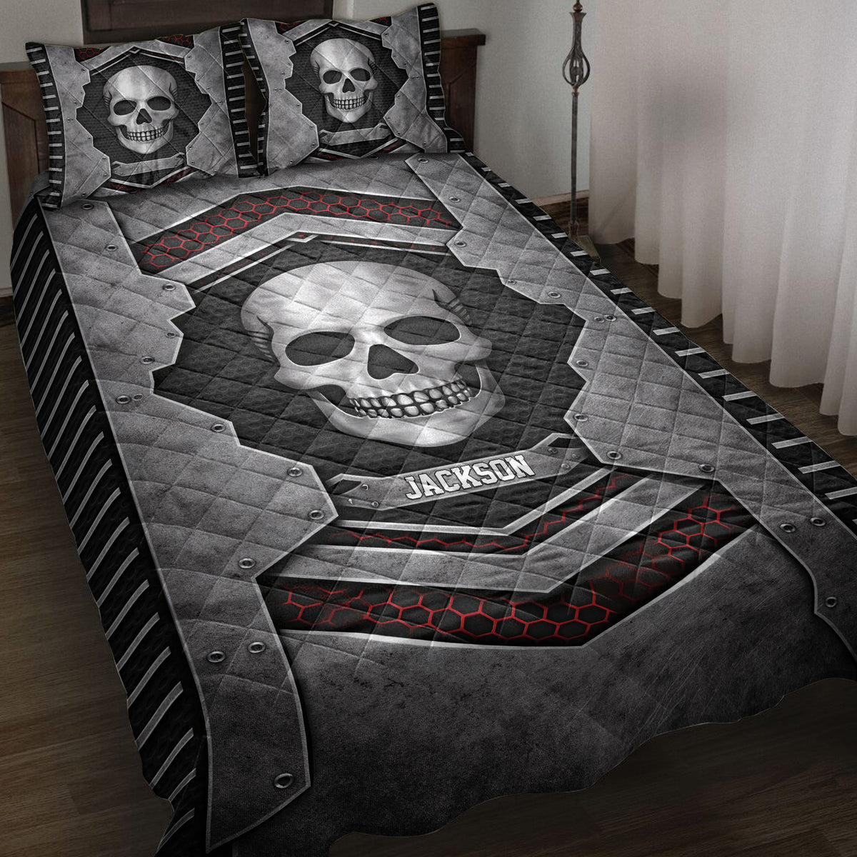 Skull quilt blanket spread across a bed with bold black, gray, and red armor-inspired artwork