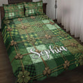 Irish quilt blanket displayed on a bed with green tartan patchwork and shamrock artwork