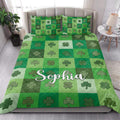 Irish shamrock quilt blanket styled on a bedroom bed with green checkerboard clover artwork