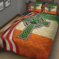 Close bedroom view of an Irish quilt blanket featuring Celtic knots, shamrocks, and Irish-American colors