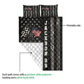 Racing quilt blanket close-up showing the printed front, white quilted backing, checkered flags, and tire motifs