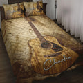 Rustic acoustic guitar quilt blanket displayed across a bedroom with guitar artwork on the pillows