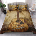 Acoustic guitar quilt blanket styled on a bright bedroom bed with matching guitar artwork