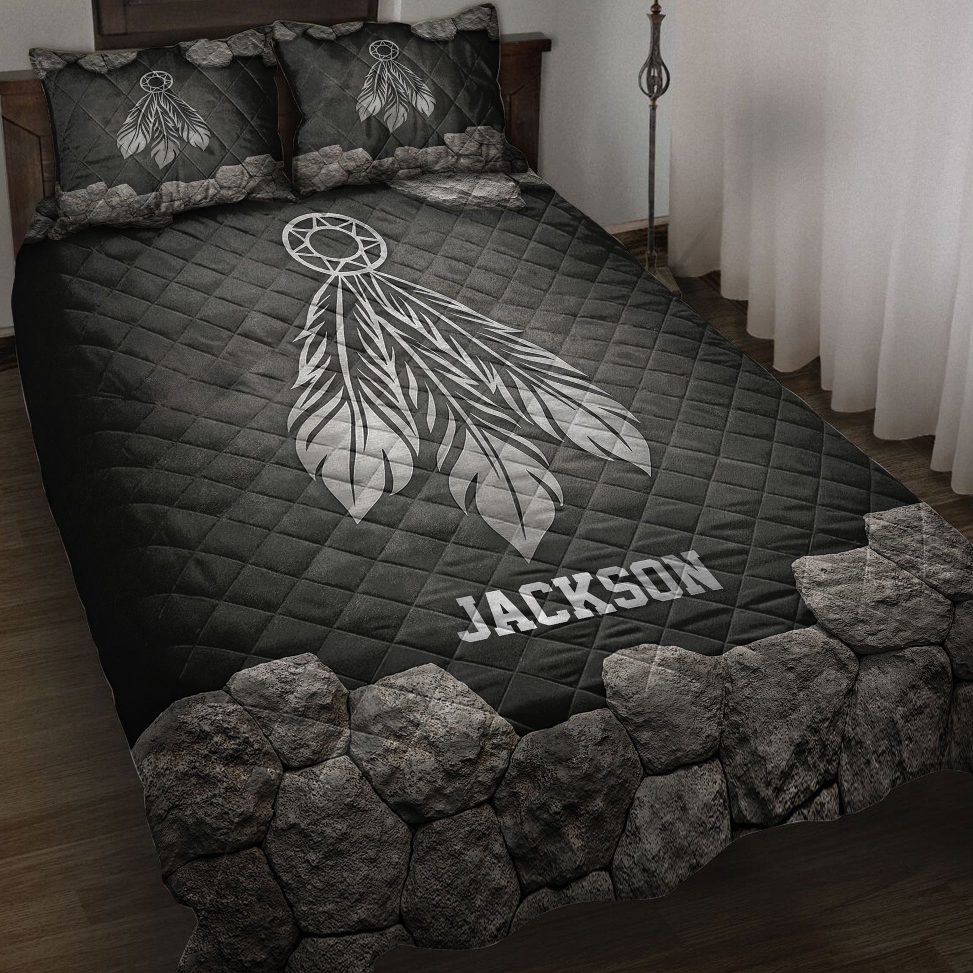 Black American Native quilt blanket with a large white dreamcatcher and feather design in a bedroom