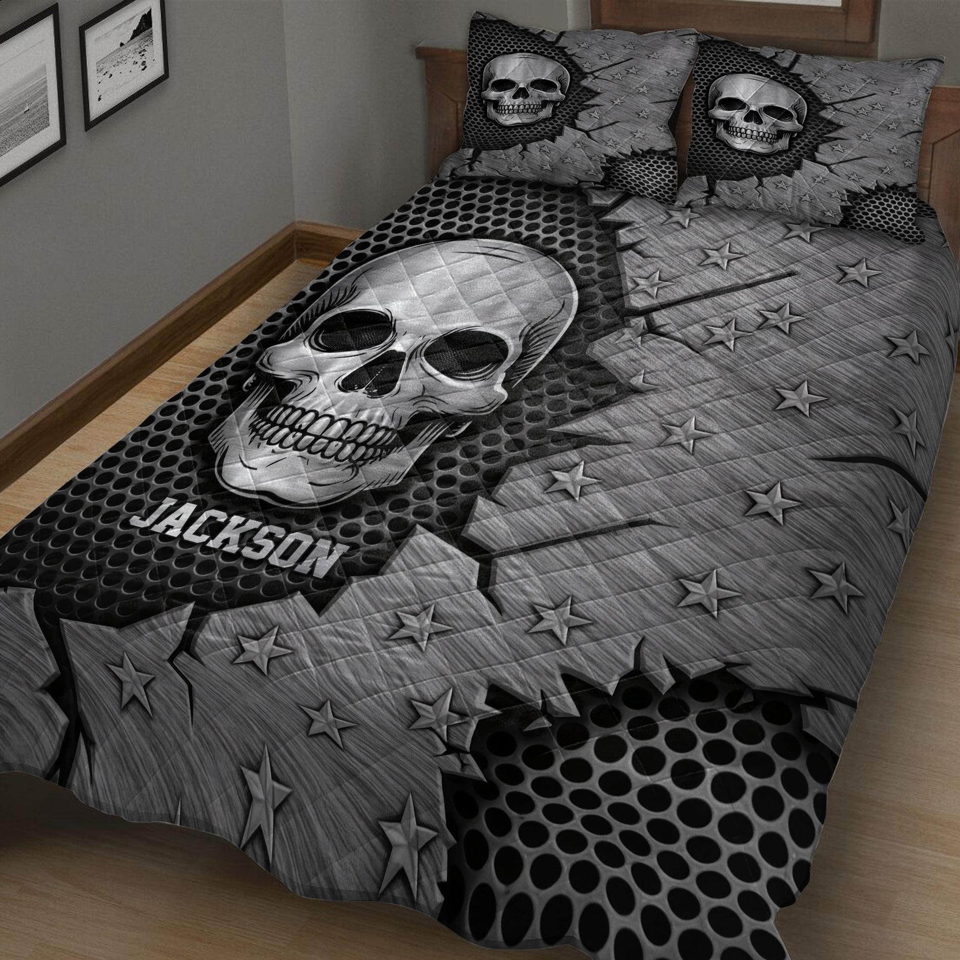 Close bedroom view of a black and gray skull quilt blanket with stars and bold skeleton artwork