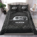 Camping quilt bedding styled on a bed with dark travel trailer and chain artwork
