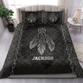 Dark dreamcatcher quilt blanket styled on a bedroom bed with feather artwork, chains, and star details