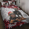 Rottweiler quilt blanket featuring Santa hats, red plaid, and snowflake artwork on a styled bed