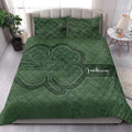 Irish shamrock quilt blanket styled in a bright bedroom with deep green Celtic-inspired artwork