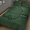 Close bedroom view of a deep green Irish shamrock quilt blanket with ornate swirling details
