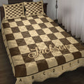 Chessboard quilt blanket in warm brown and tan tones styled on a bedroom bed with matching pillows