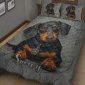 Close view of black and tan dachshund artwork across a quilted bedspread