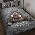 Pitbull quilt blanket displayed on a bed with gray cracked-stone artwork and matching dog portrait details