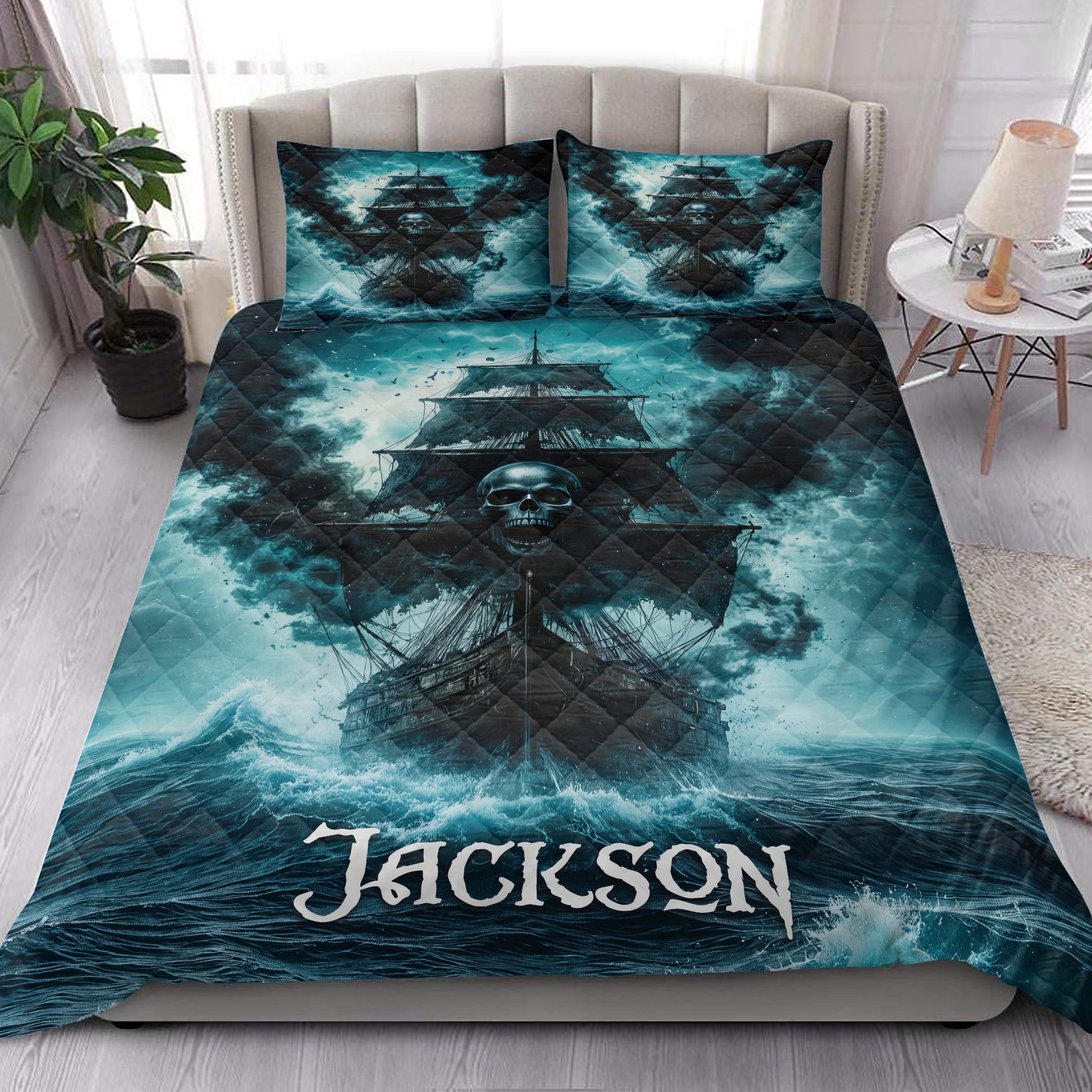 Pirate quilt bedding styled on a bedroom bed with dramatic skull ship artwork in teal and black tones
