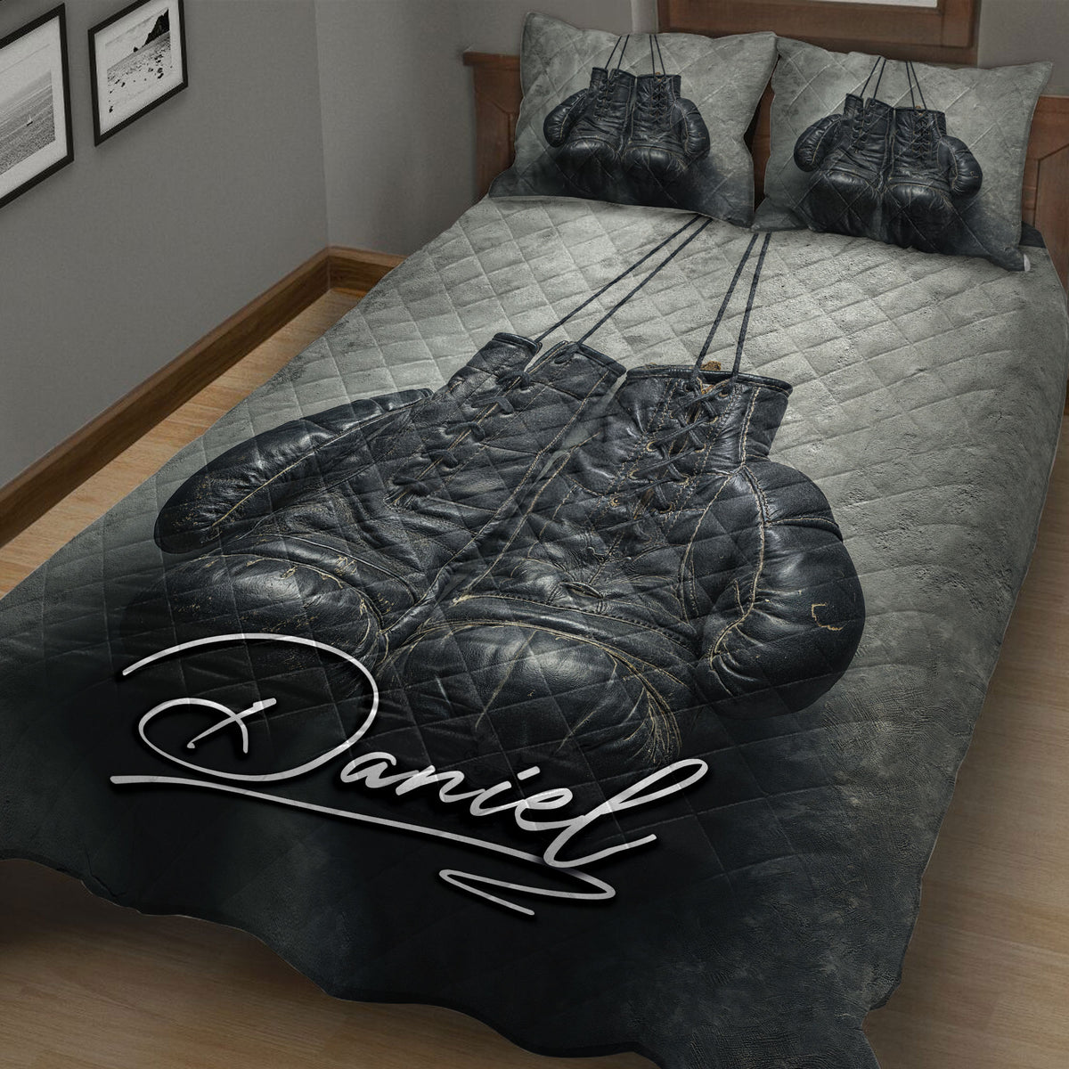 Close bedroom view of a black and gray boxing gloves quilt blanket with gold accents