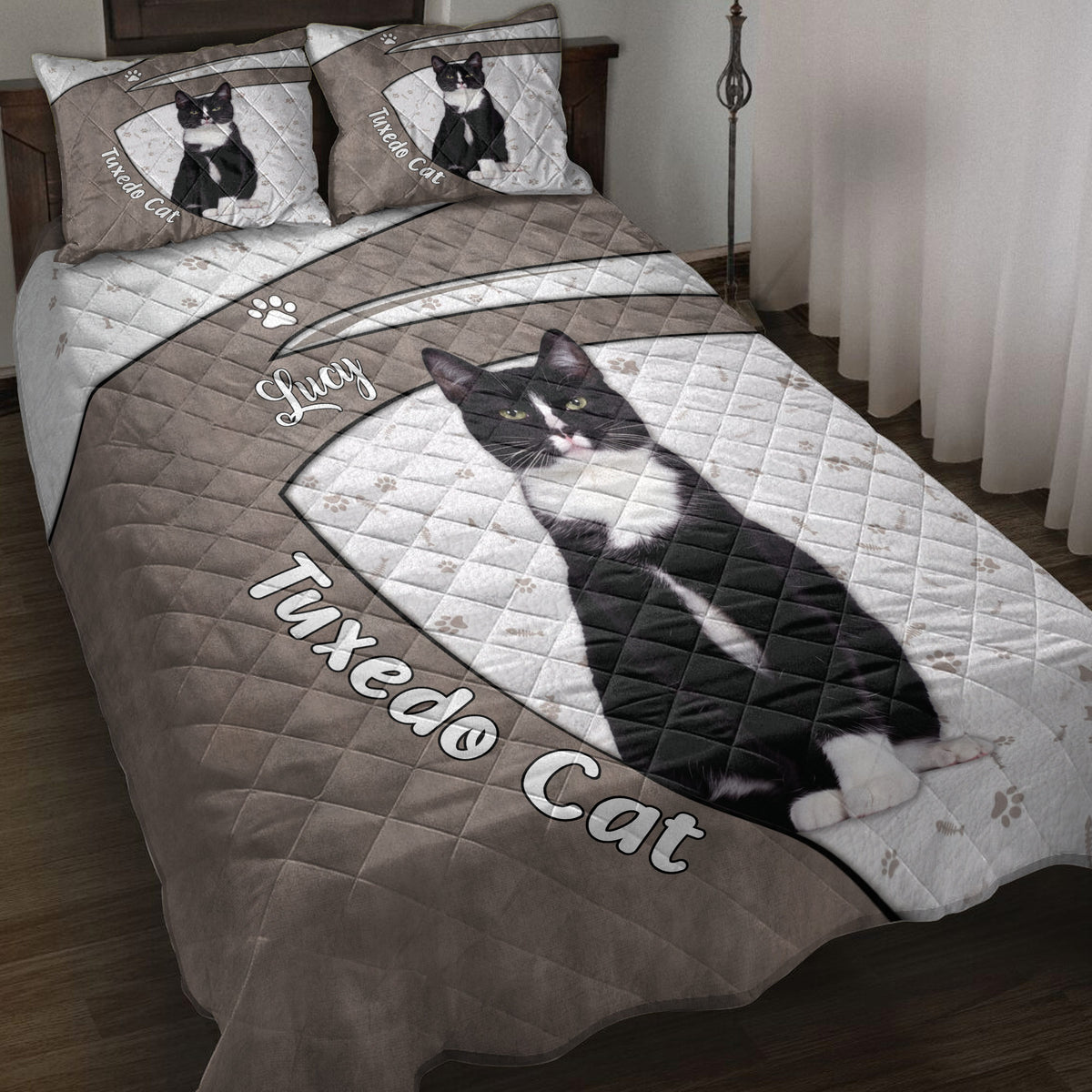 Tuxedo cat quilt blanket displayed on a bed with paw prints, fish bones, and black-and-white cat artwork