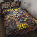 Motocross quilt blanket displayed on a bed with dirt bike rider artwork in black, orange, and yellow