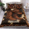 Cowboy quilt bedding styled in a bedroom with large Western hat and boot artwork in brown and black tones