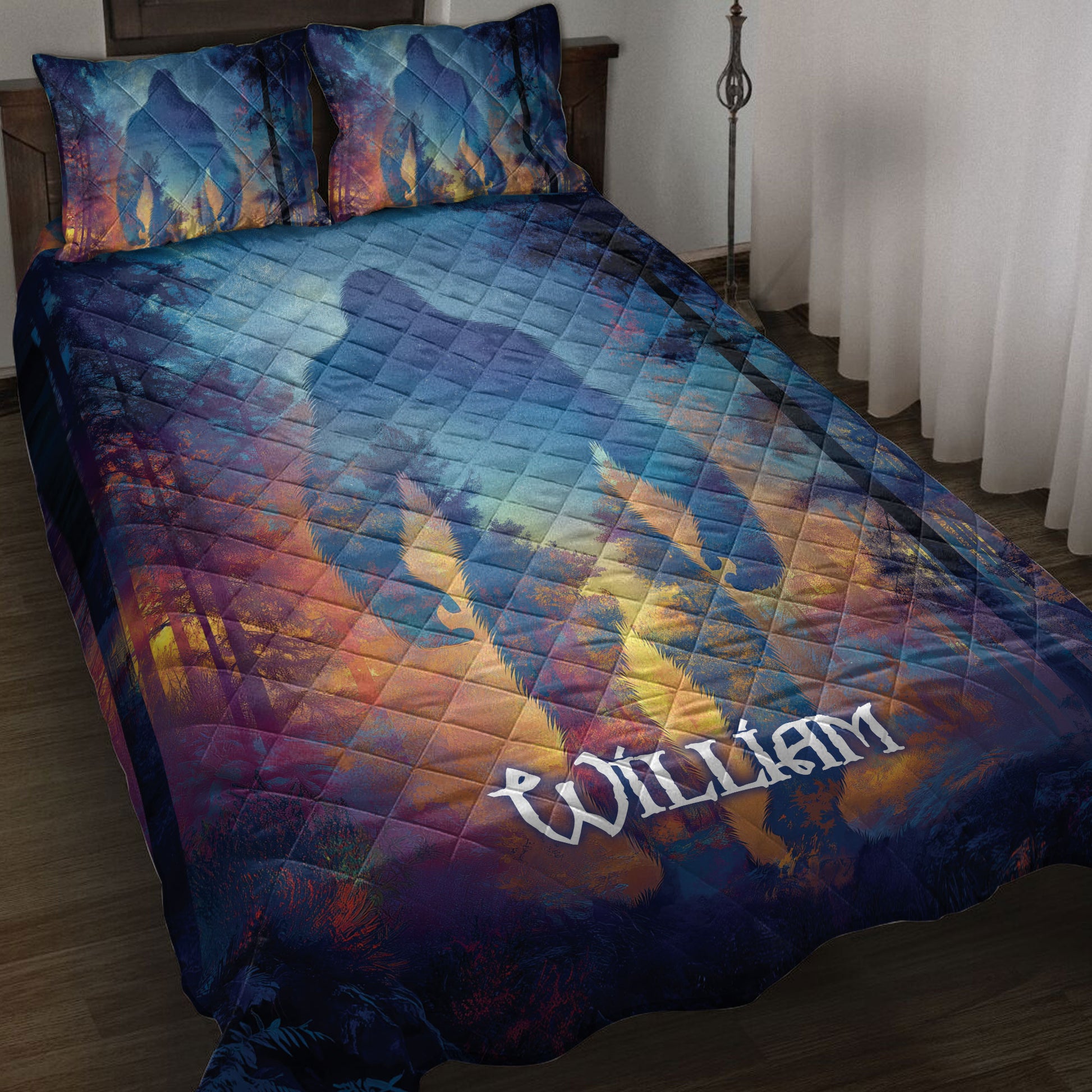Bigfoot quilt blanket spread across a bed with colorful forest artwork in blue, purple, and gold tones