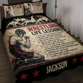 Wrestling quilt blanket displayed on a bed with grappling silhouettes, red stars, and motivational sports artwork