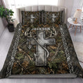 Hunting quilt blanket styled on a bedroom bed with deer antlers, camouflage leaves, arrows, and rustic outdoor artwork