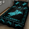 Black and turquoise rodeo quilt blanket featuring a large bull rider, bucking bulls, and western pattern details