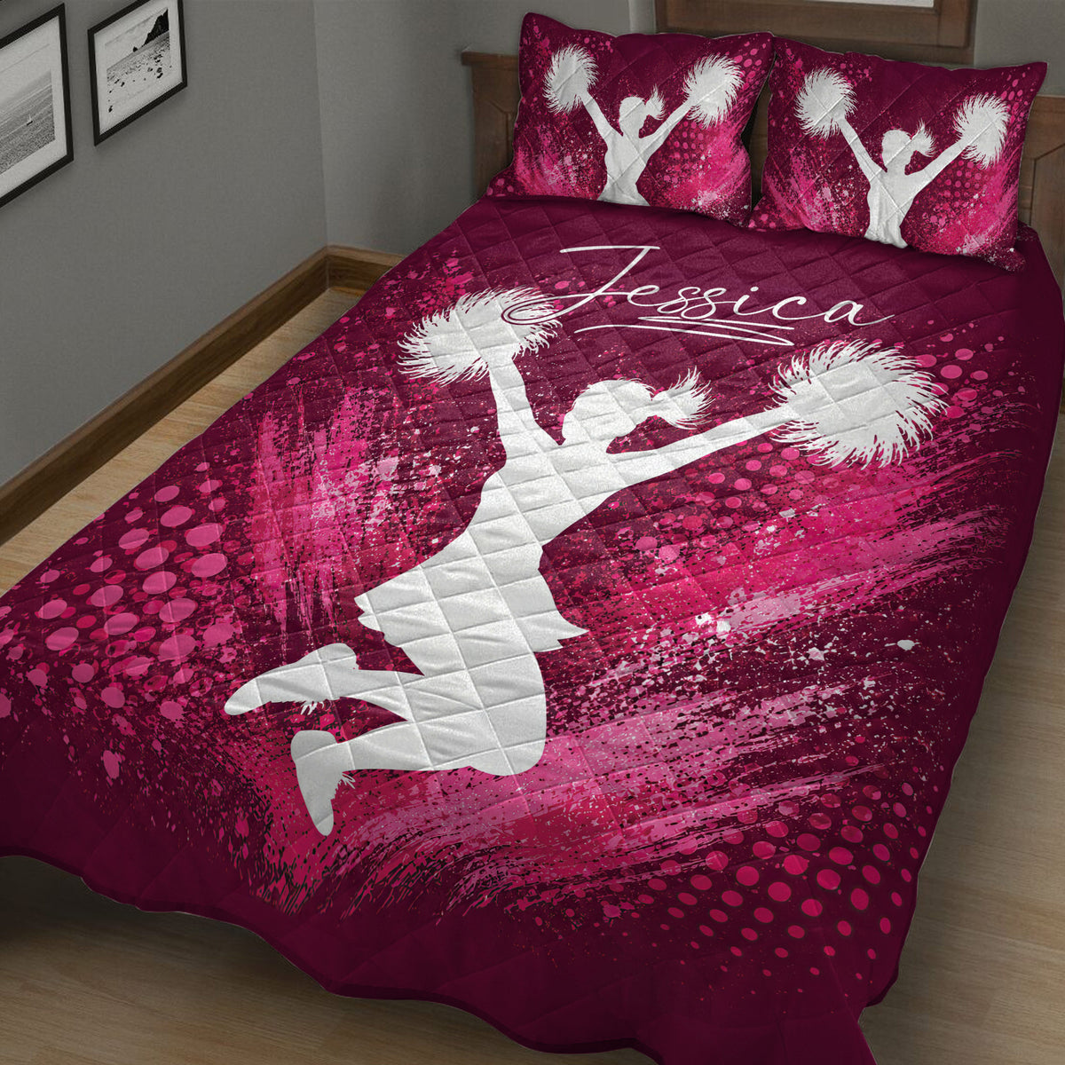 Burgundy and pink cheerleading quilt blanket displayed at an angle with dynamic pom-pom silhouettes
