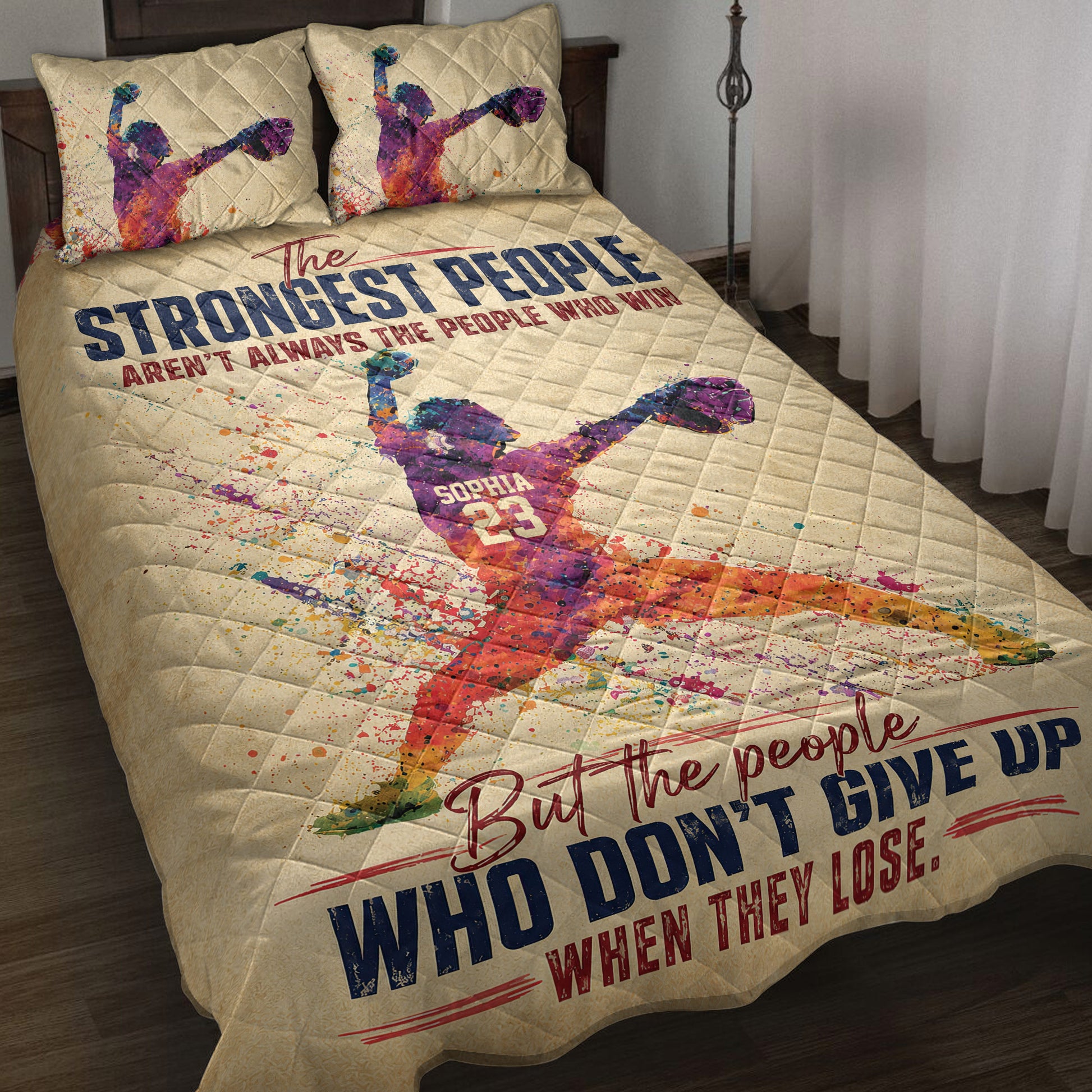 Softball quilt blanket displayed on a bed with colorful female pitcher artwork and motivational sports design